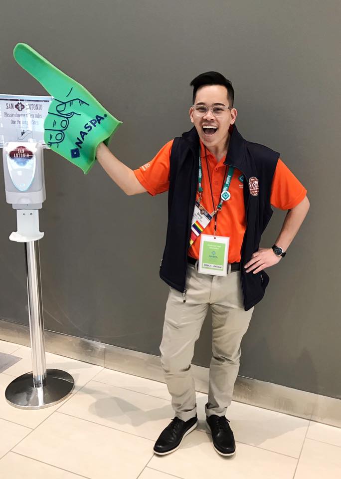 An individual holds up a green foam finger