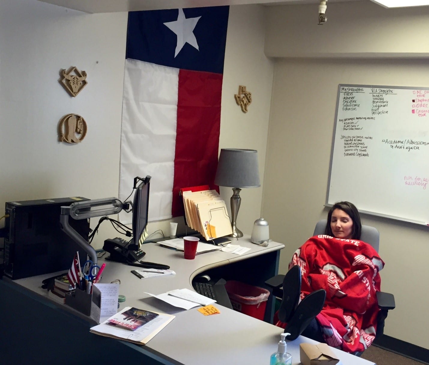 A student sits at desk, wrapped in OSU blanket