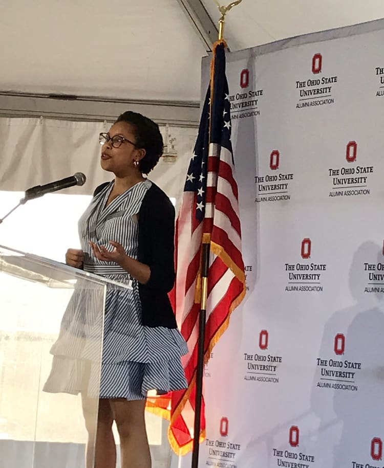 A woman at a podium talks into a microphone