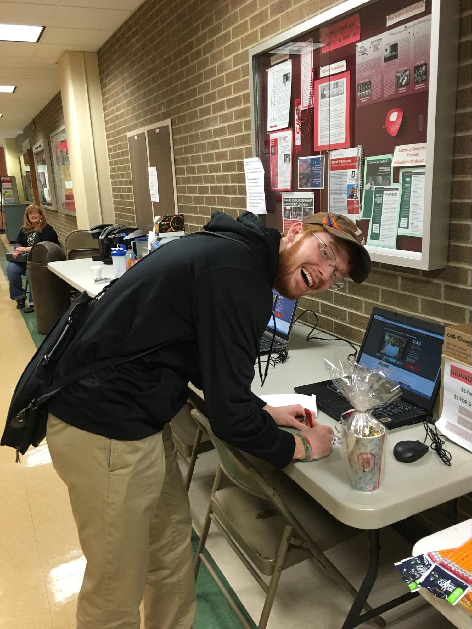 Student filling out raffle tickets with wide smile