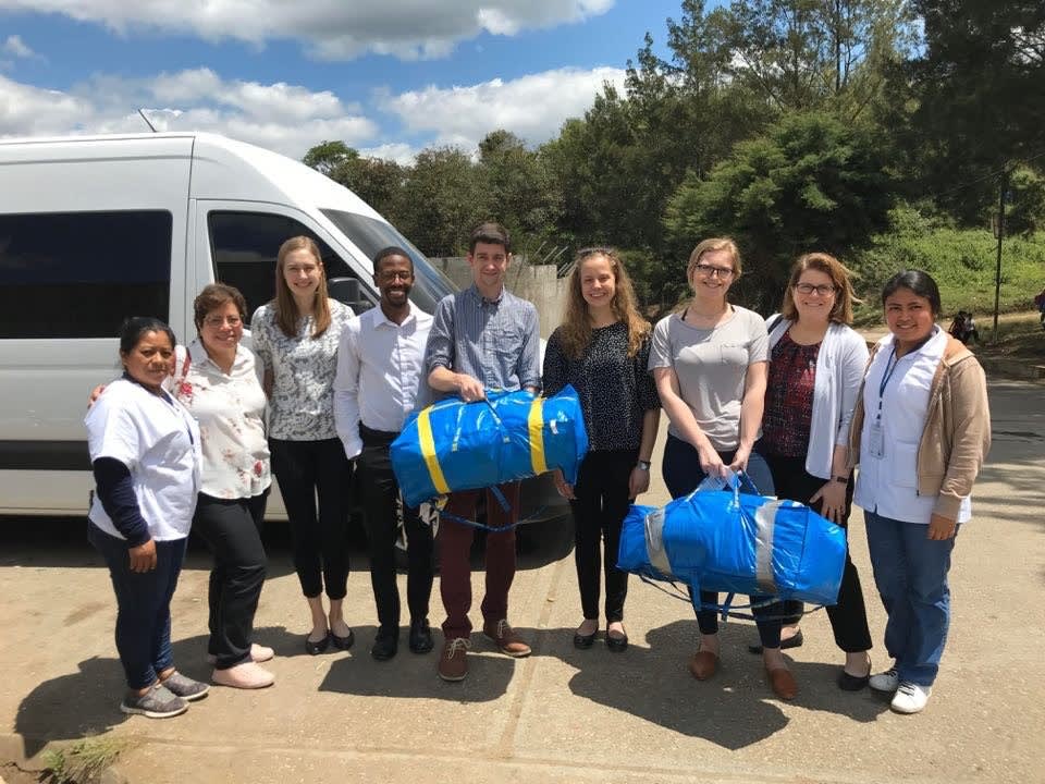 Students in Guatemala holding large blue bags