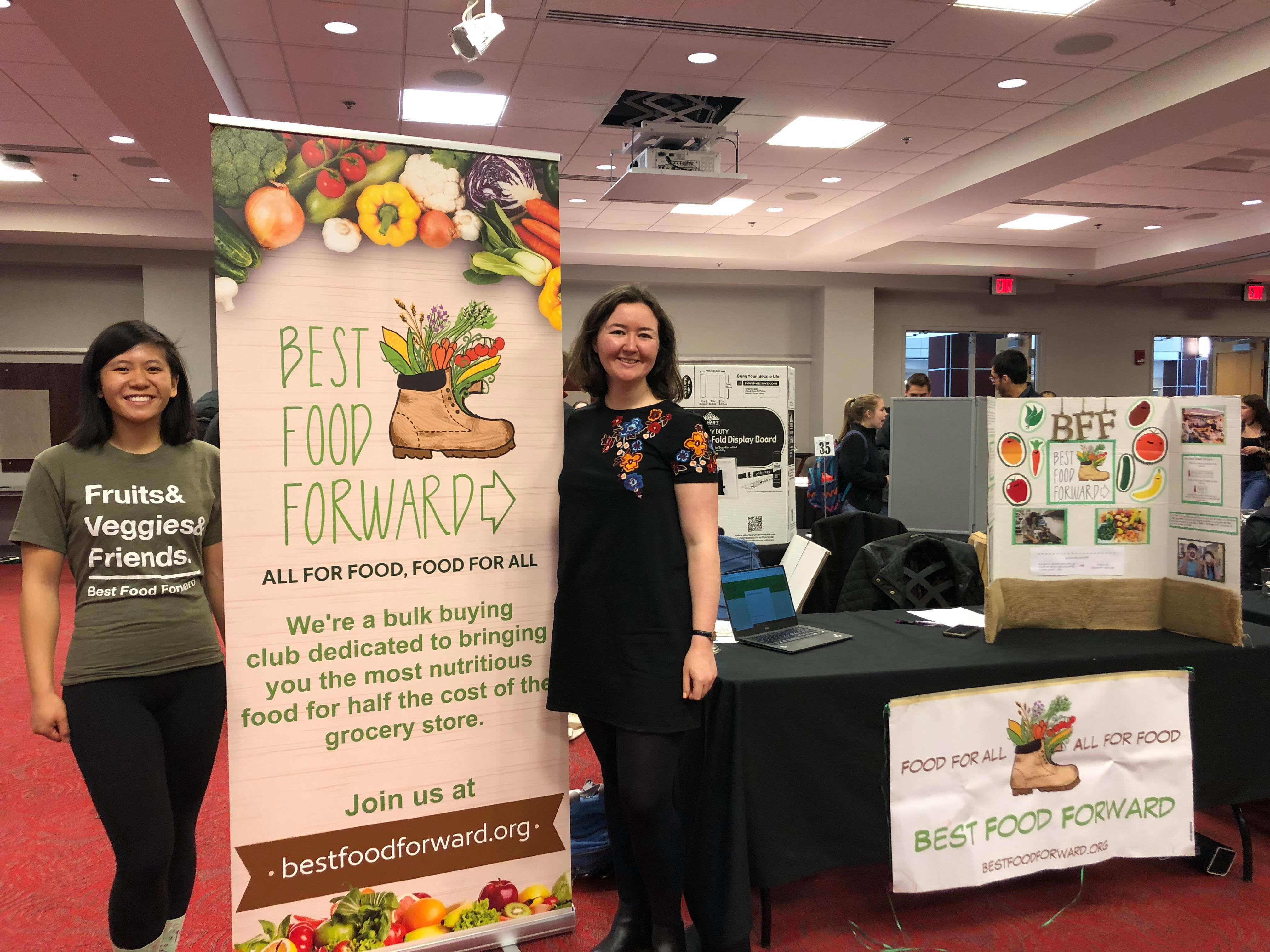 Two individuals around a Best Food Forward banner