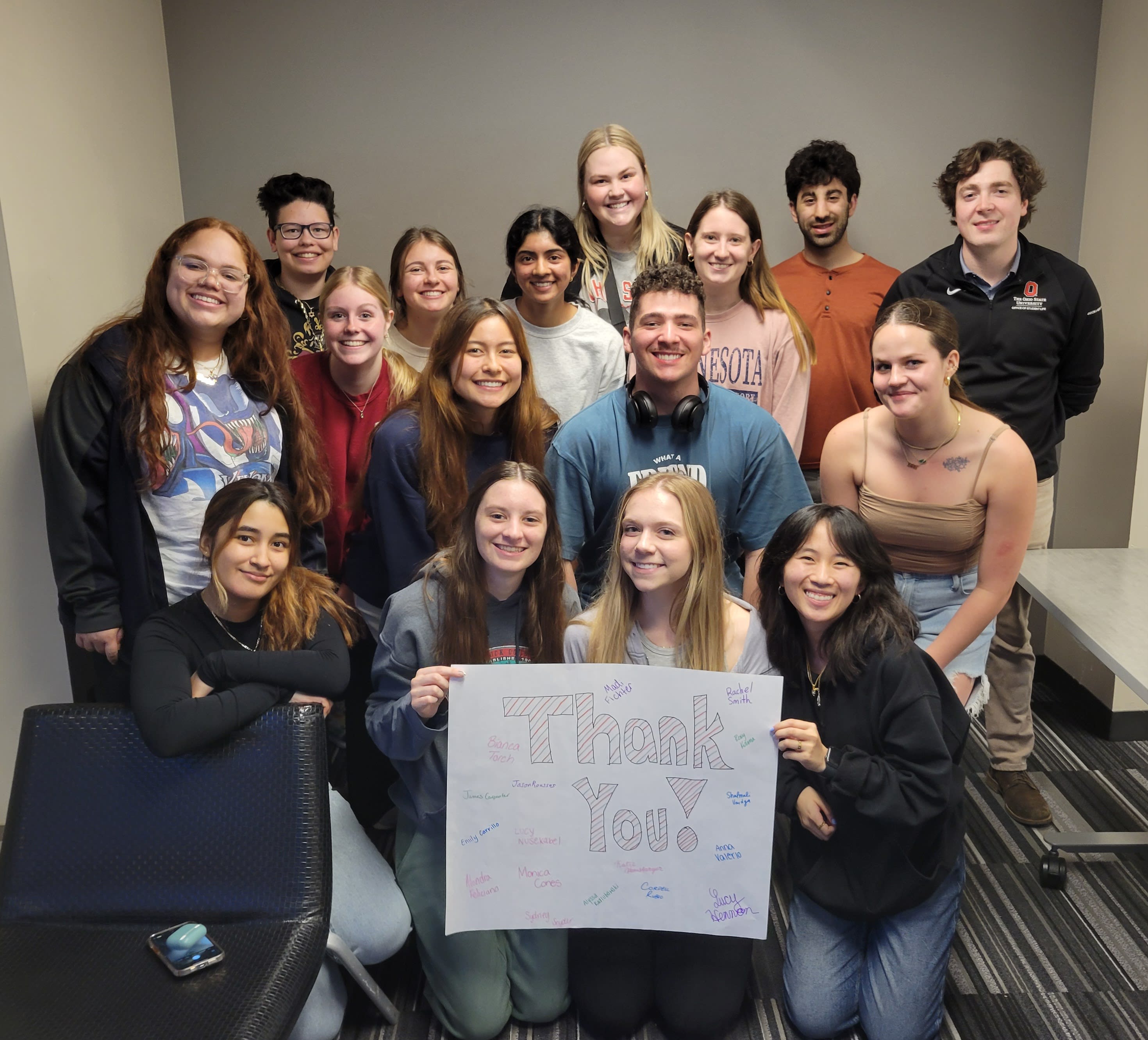 Group of students surrounding a Thank You poster