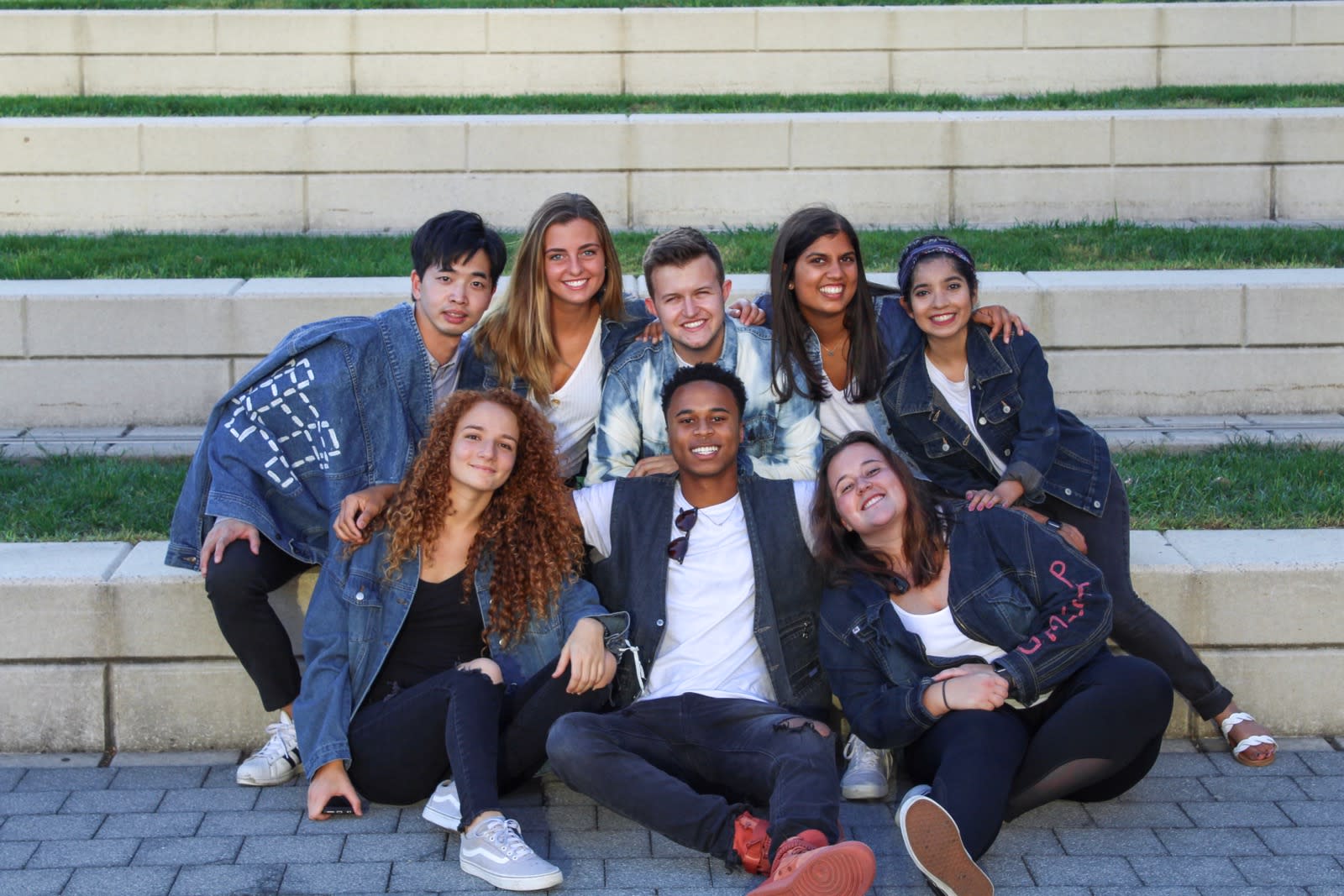 8 students sitting together on brick stairs