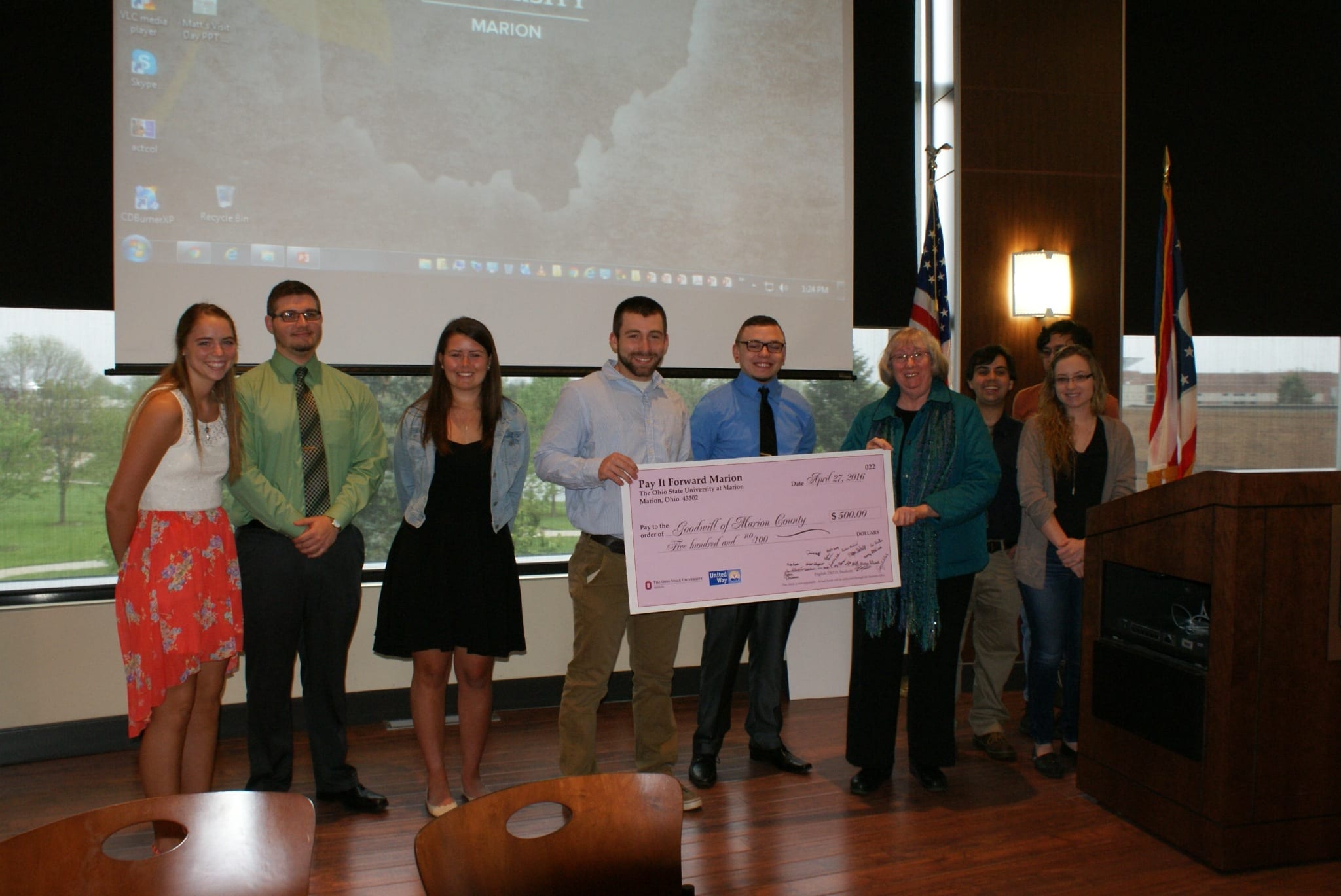 Students accepting check for Goodwill