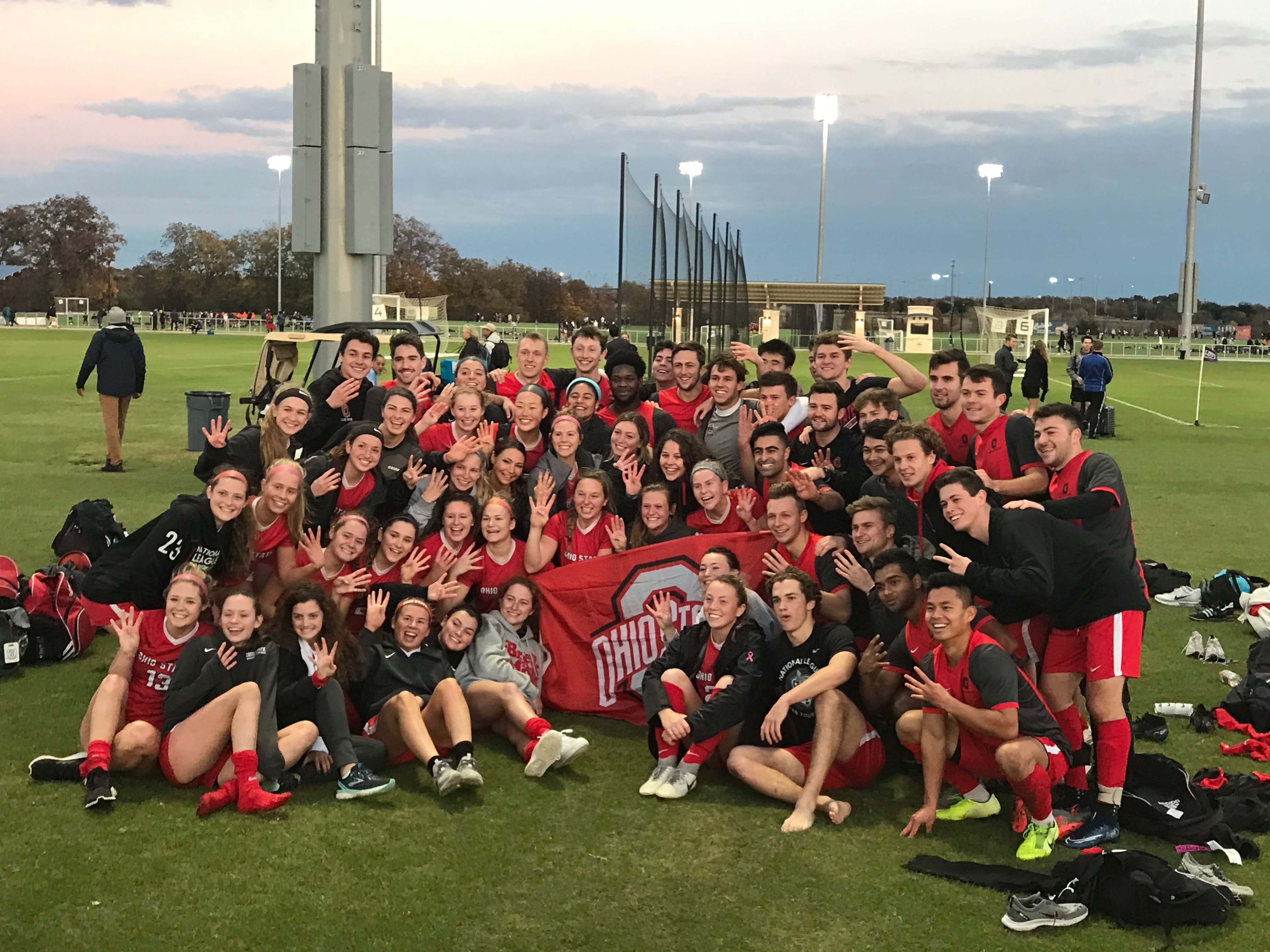 Club teams posed on field, holding up 4 fingers