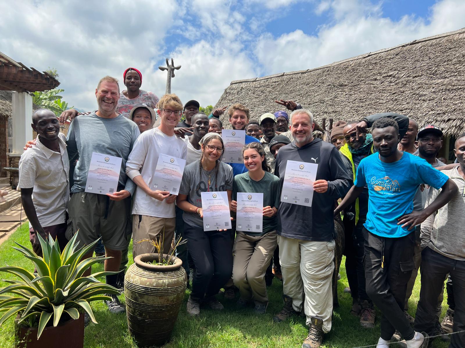 A large group holding certificates in village