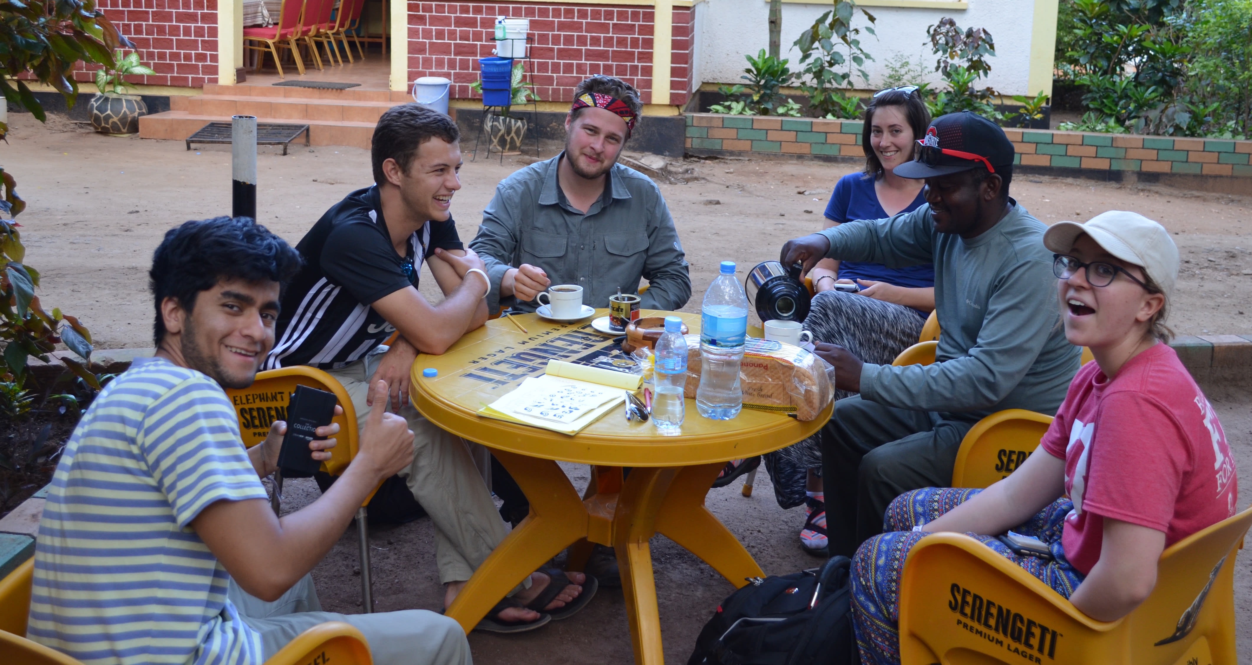 Six individuals sit around a small, yellow table