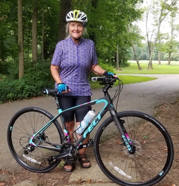 Nancy Lahmers stand beside a black bike