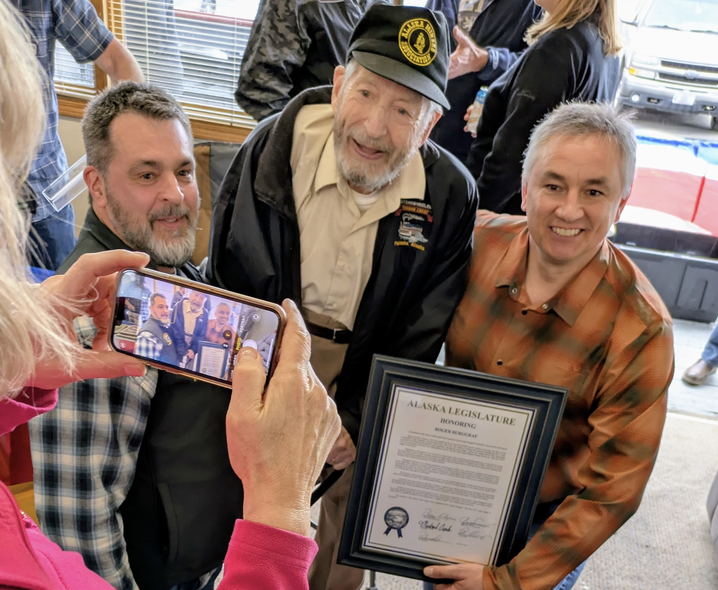 Three men pose for a photo.