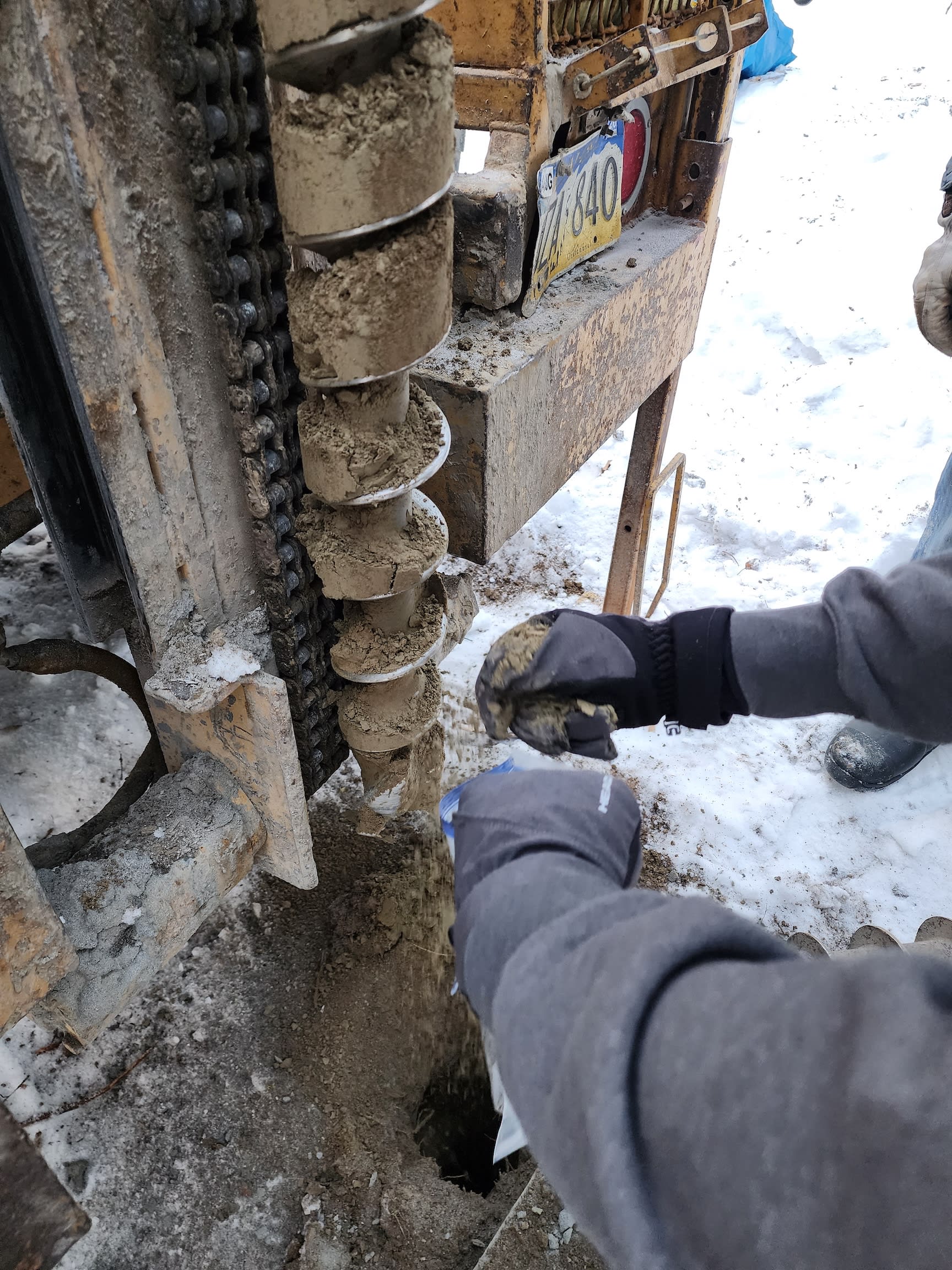 A drill removes soil from the ground.