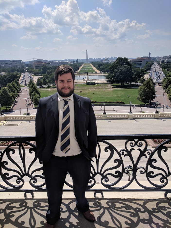 Frank Bumb standing before a large field with the Washington Monument in the distance