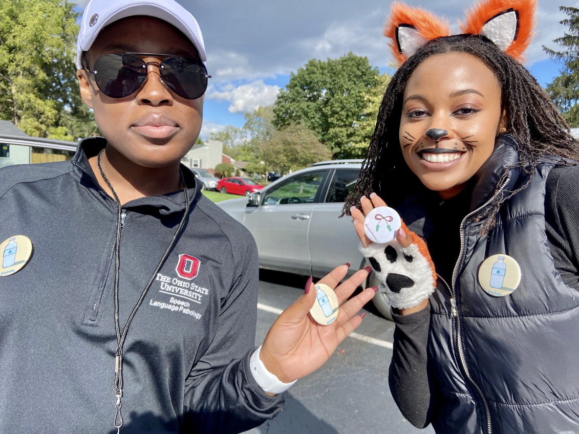 A'Niyah and Amber posed for a picture. One wears fox ears with a painted cat ear and whiskers