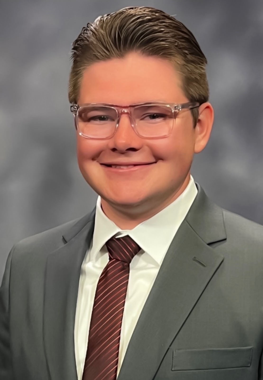 Jackson Crawford's headshot. He wears a suit and tie in the picture