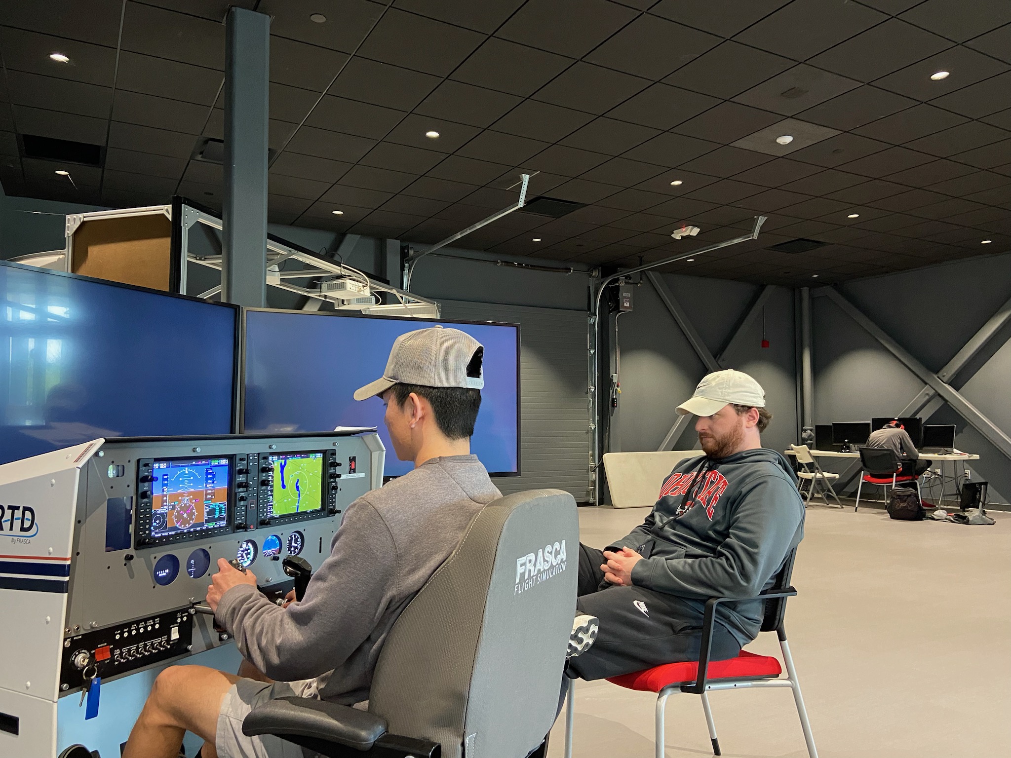 Two students practicing on flight simulators