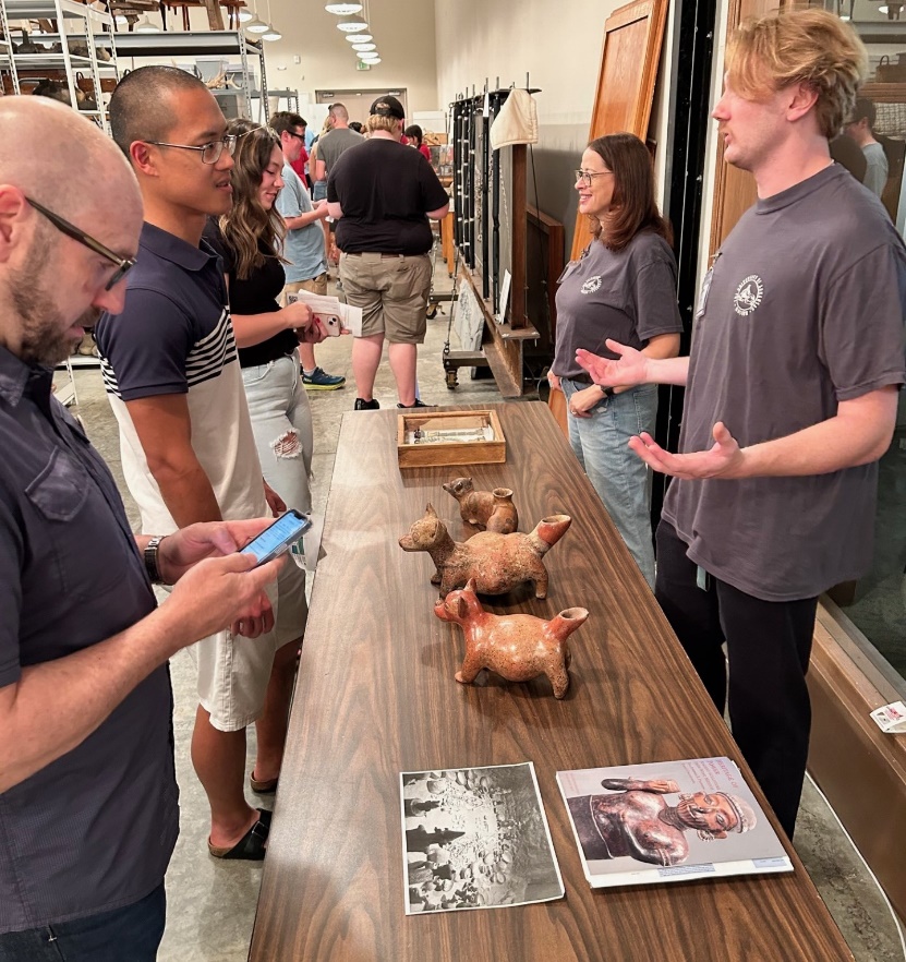 A group of people standing around a table with objects on it
Description automatically generated