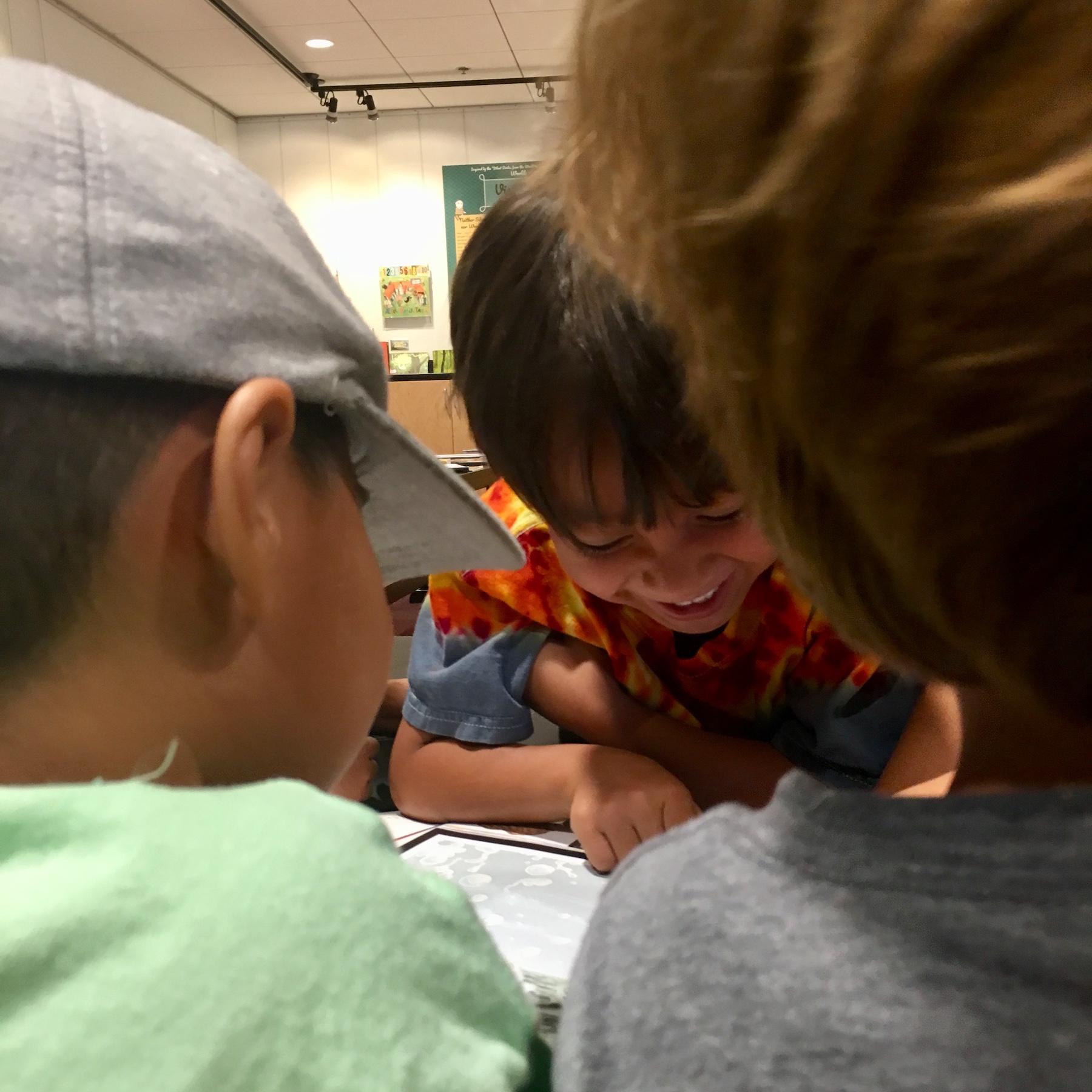 Three children excitedly read outside an exhibit