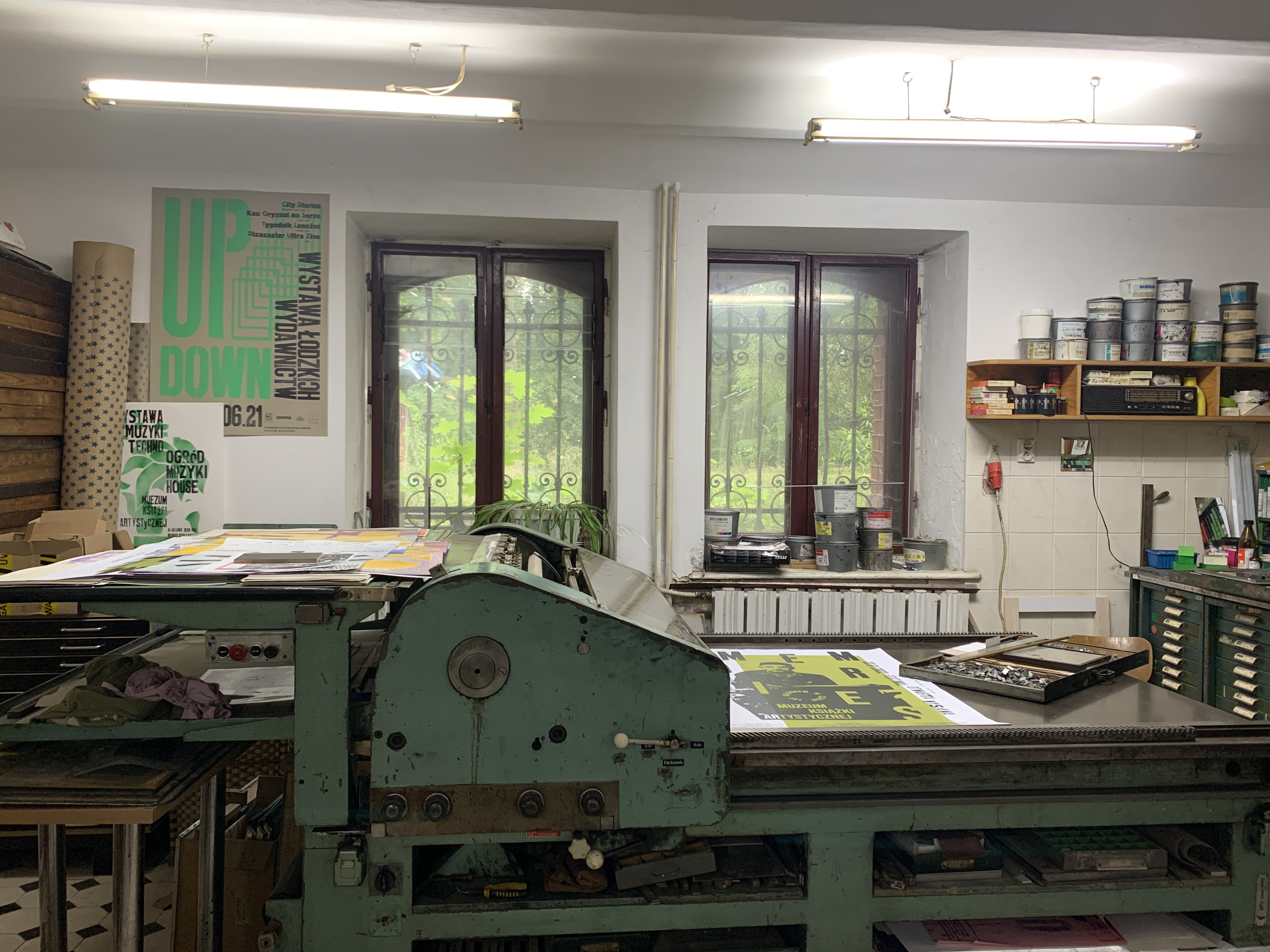 A printing press that sits on the left side of a working space 