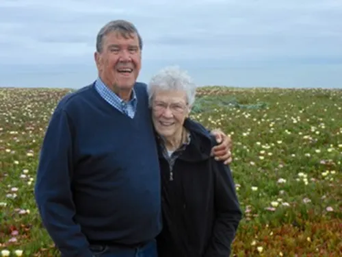 A person and person standing in a field of flowers

AI-generated content may be incorrect.