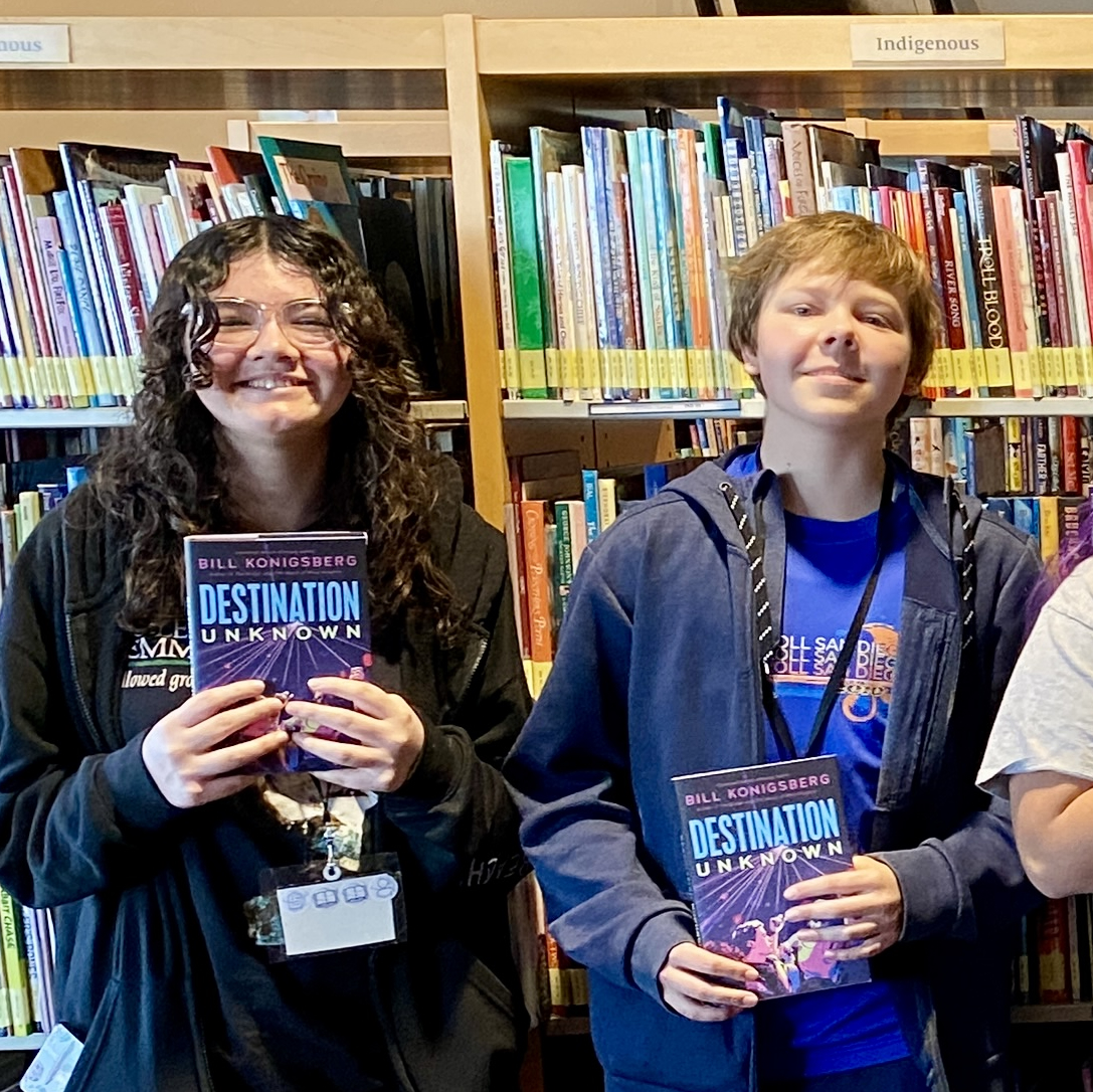 Smiling teens holding copies of the same book