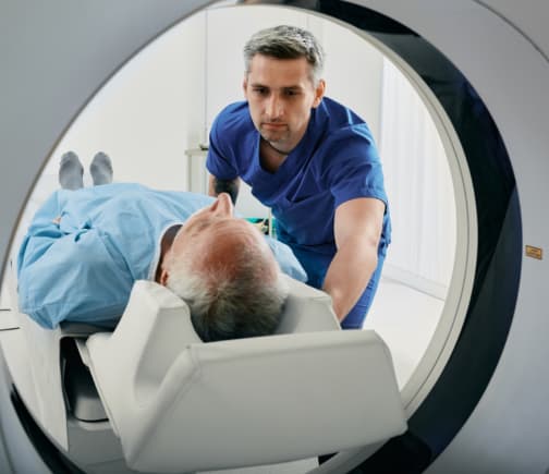 A doctor placing a man in an MRI scanner