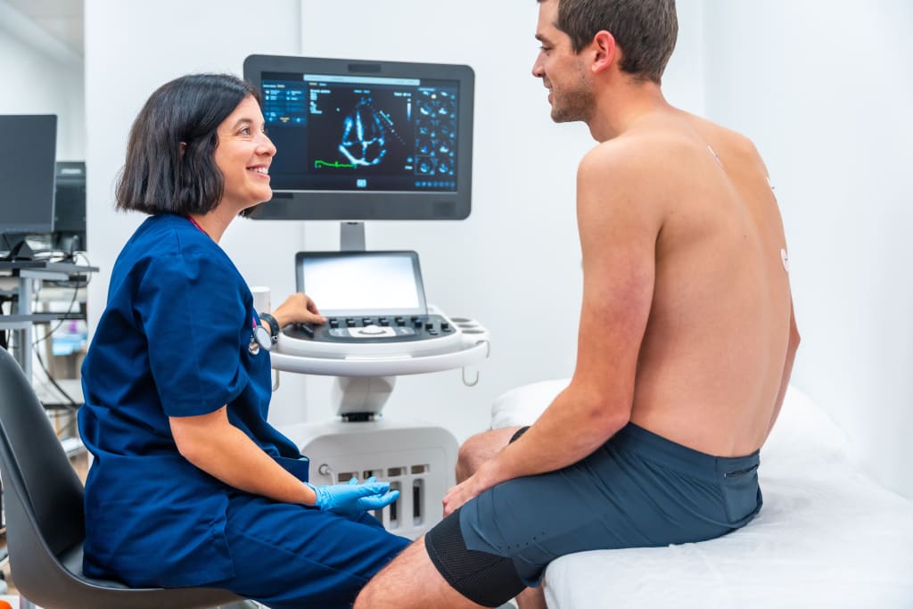A female doctor explains echocardiogram results to a male patient.