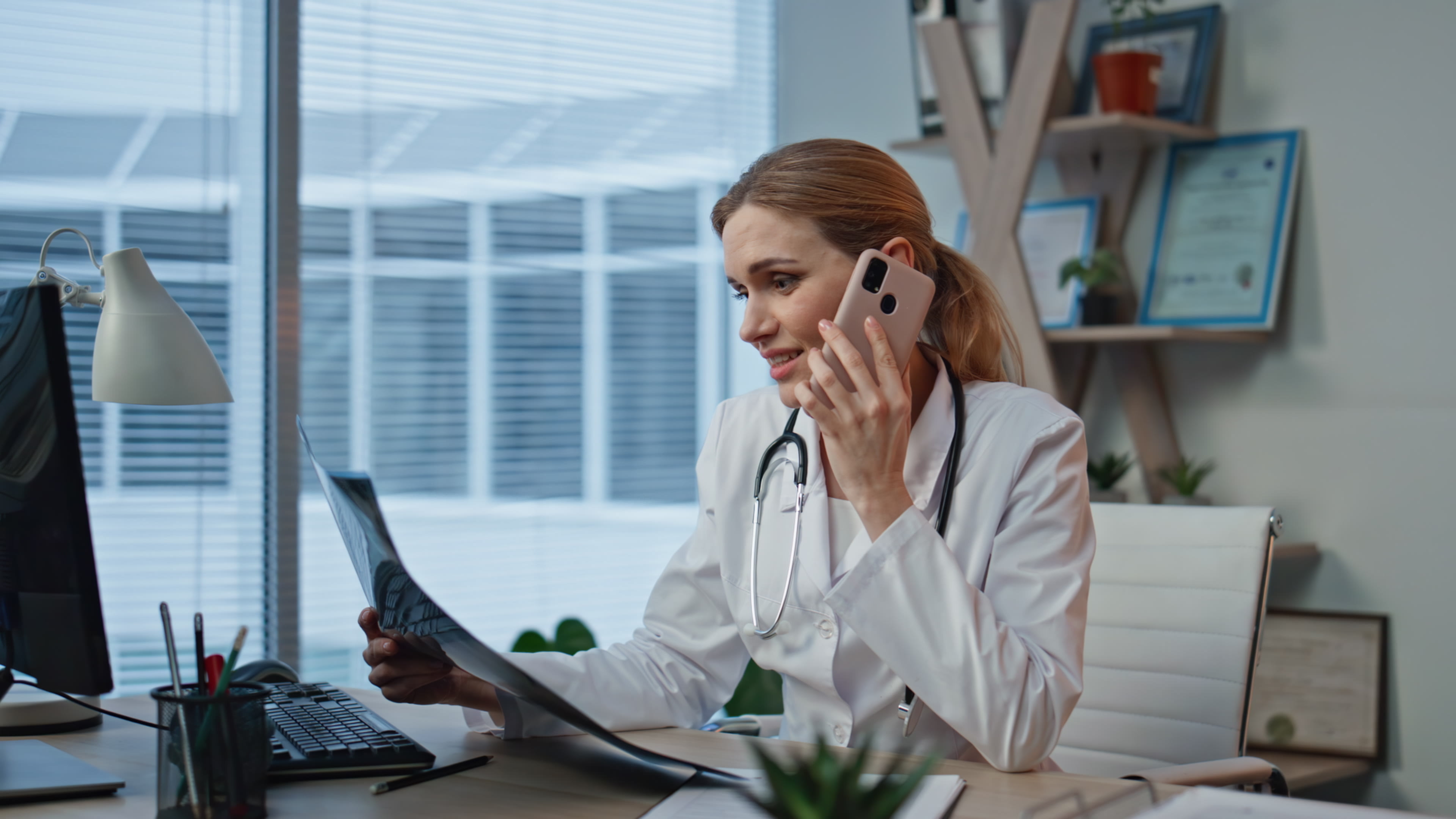 A female doctor on the phone while holding radiology results