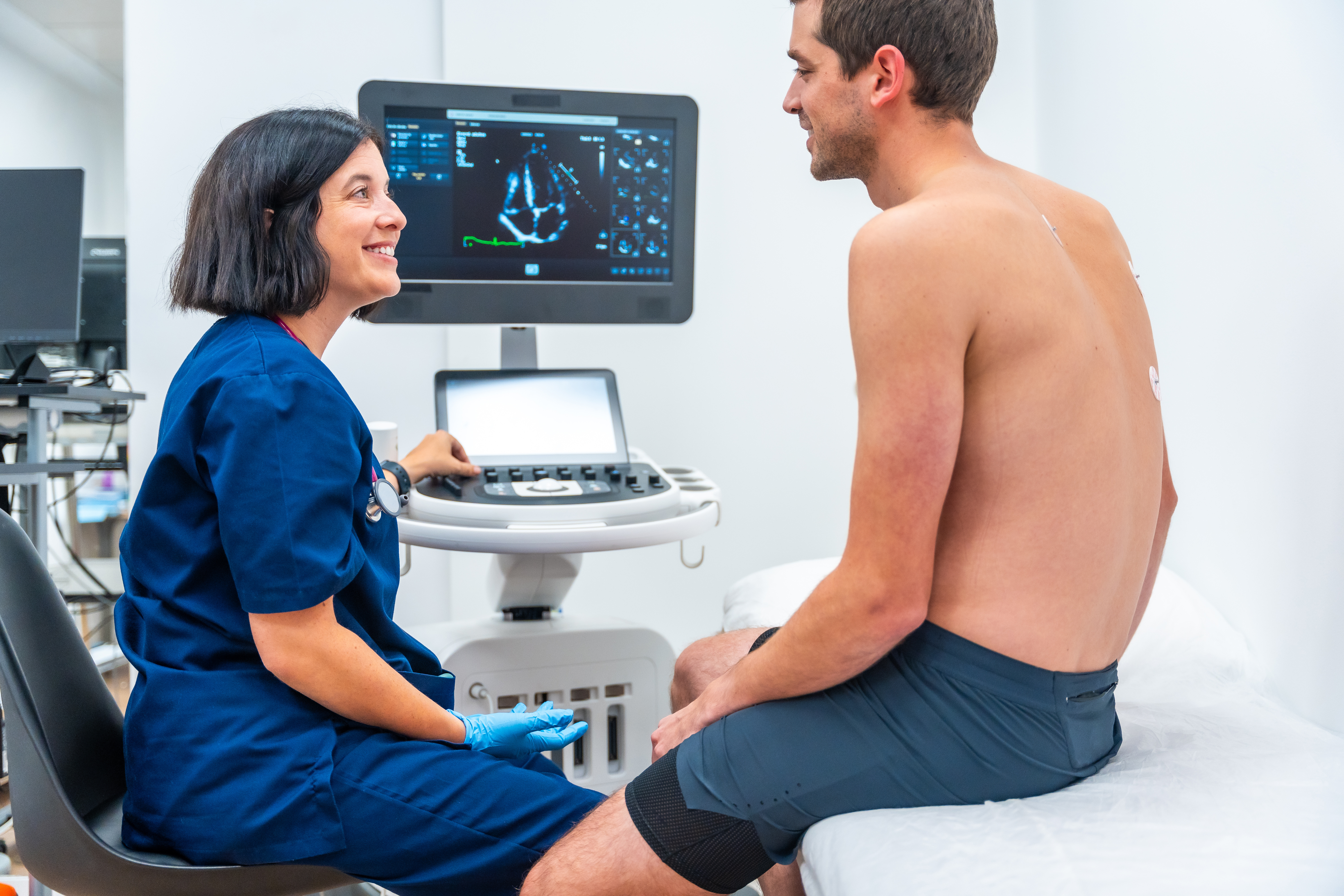 A female doctor explains echocardiogram results to a male patient.