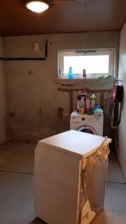 Vaskemaskinen i rommet har avlu00f8p i vegg mot bad