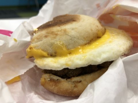 an egg and cheese sandwich on an english muffin, wrapped in paper
