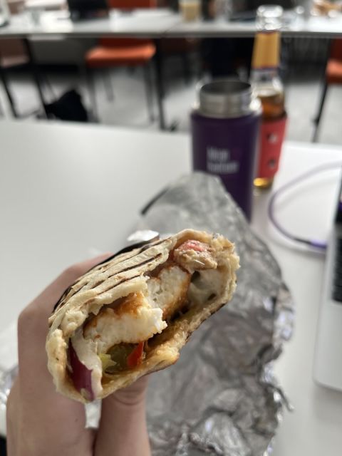 A partially eaten pita with fried haloumi cheese.