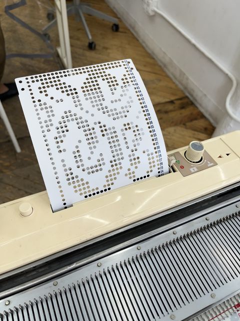 Punch card inserted into the card reader on the knitting machine.