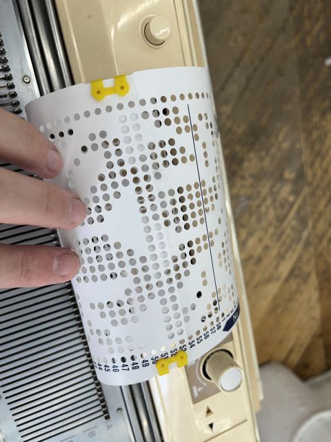 Detail of the punch card with plastic clips joining the start and end edges to form a loop.