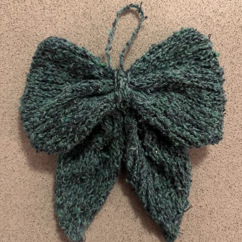 A small bow knit from fuzzy green yarn.