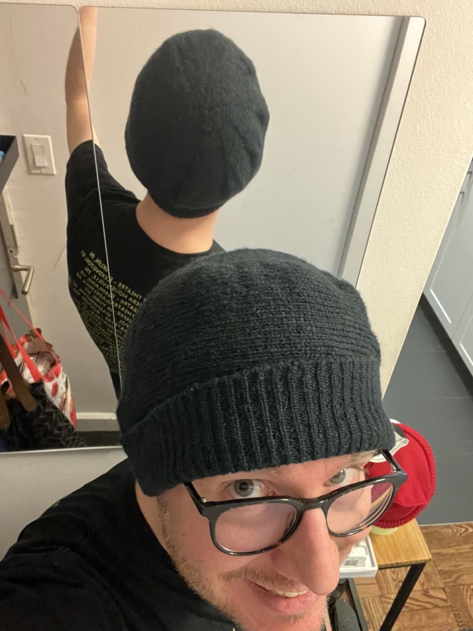 Posing with the hat in a mirror, so the front and back are visible. It sits loose on my head.