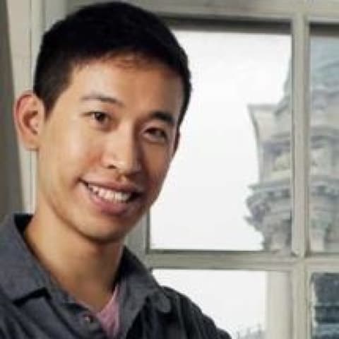 man smiling in front of window