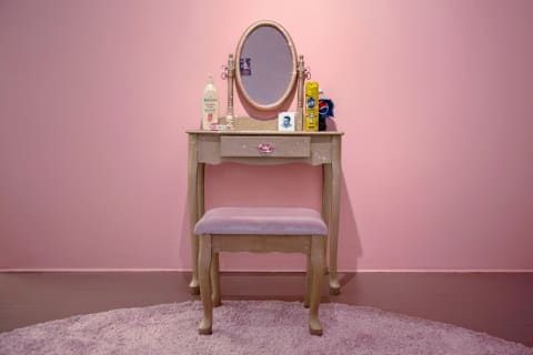 A photo of an art installation of glitter on an oak vanity set with sequins.