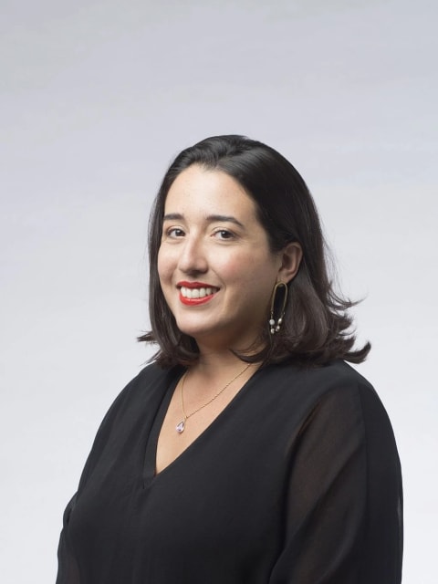 A headshot of a woman with shoulder-length brown hair and red lipstick (Marina Reyes Franco)