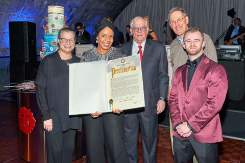 A photograph of NYC Cultural Affairs Commissioner Laurie Cumbo presenting a special 75th-anniversary proclamation to SVA president David Rhodes and a group of SVA employees.