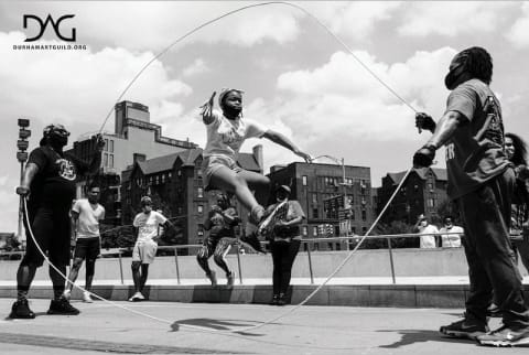 A girl jumping rope while people watch