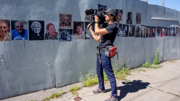 MFA SocDoc student holding a camera on the street.