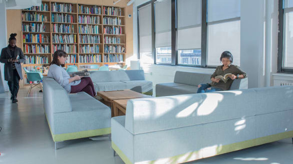Students sitting on sofas reading in MA Curatorial Practice lounge.