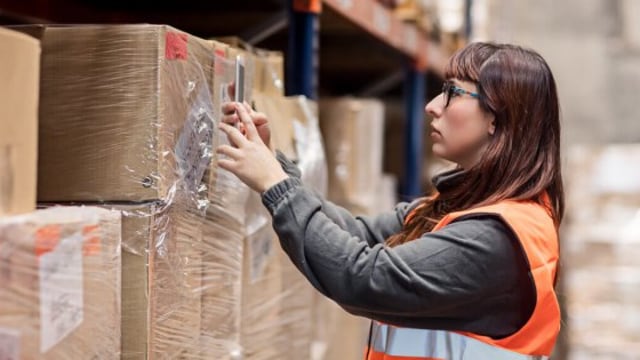 woman scanning boxes from shelves