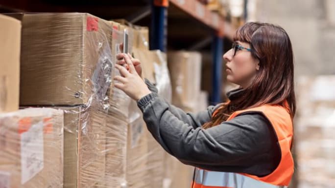 woman scanning boxes from shelves