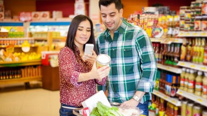 two smiling people scanning a product