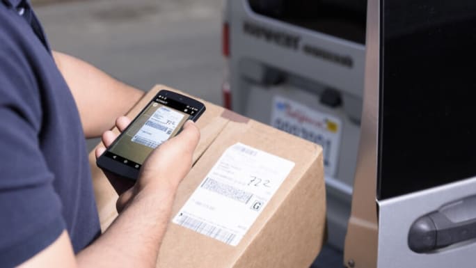 Delivery man scanning package label