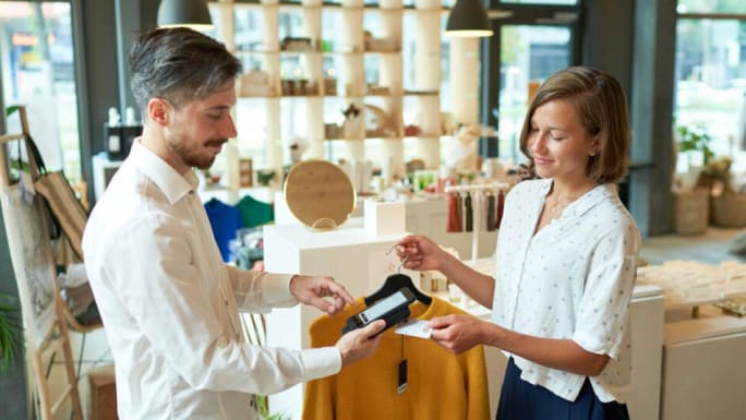 User paying in fashion store with mobile scanning