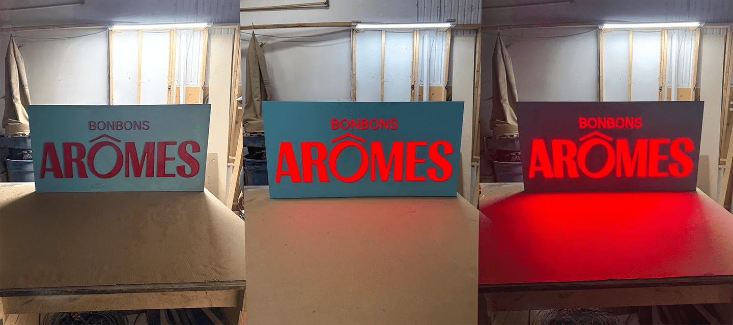 Enseigne push-through Bonbons Arômes : lettres d’acrylique traversant une face d’aluminium, vue éteinte, allumée de jour et allumée de soir