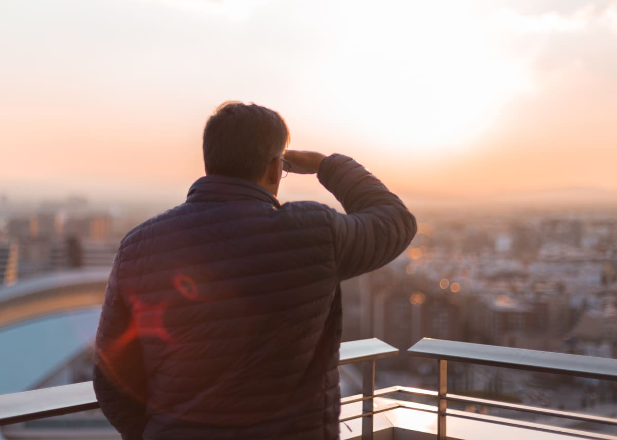 man watching rooftop sunset