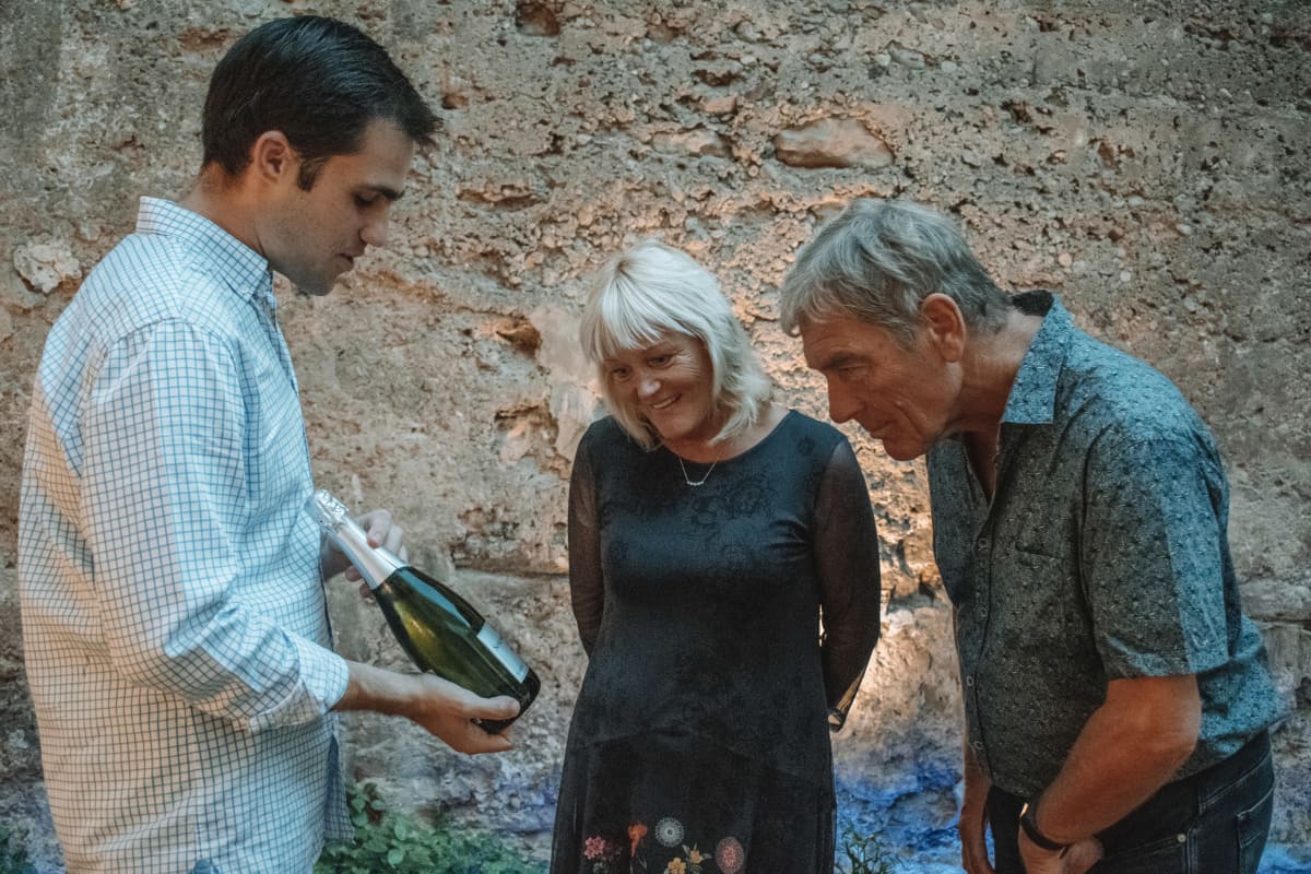 Host explaining wines to couple